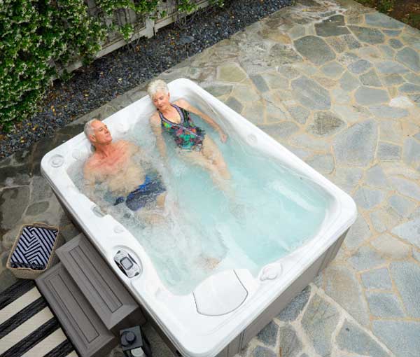 Aerial view of couple enjoying their Kauai Caldera Spa | Caldera Spas available at the Recreational Warehouse Southwest Florida (Naples, Fort Myers and Port Charlotte Locations) Pool Warehouse