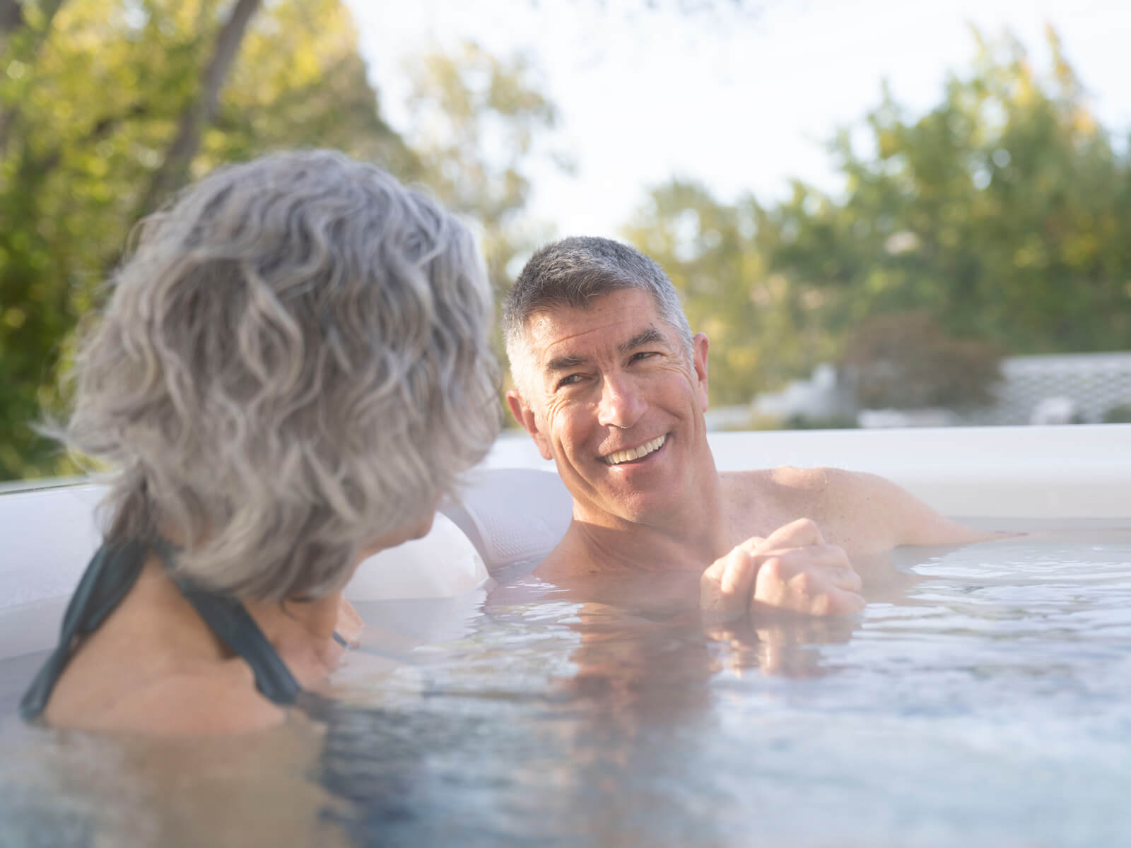 Man laughing with woman inside Grandee Hot Tub Spa | Hot Springs Spas available at the Recreational Warehouse Southwest Florida (Naples, Fort Myers and Port Charlotte Locations) Pool Warehouse